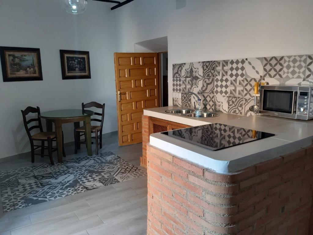 阿尔玛格鲁Casa Rural San blas的厨房配有带微波炉的柜台和桌子。