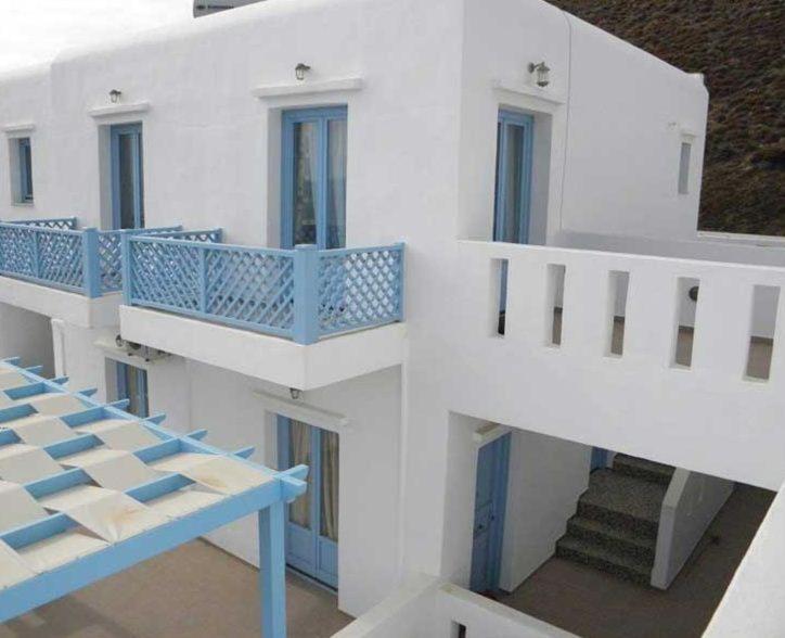 阿斯提帕莱亚镇Votsalo的白色的建筑,设有蓝色的阳台和楼梯