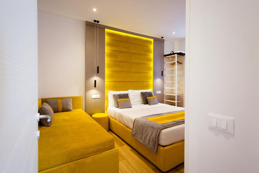 斯培西亚Elegant Apartments 5 terre la spezia的一间卧室配有一张床和一个黄色床头板