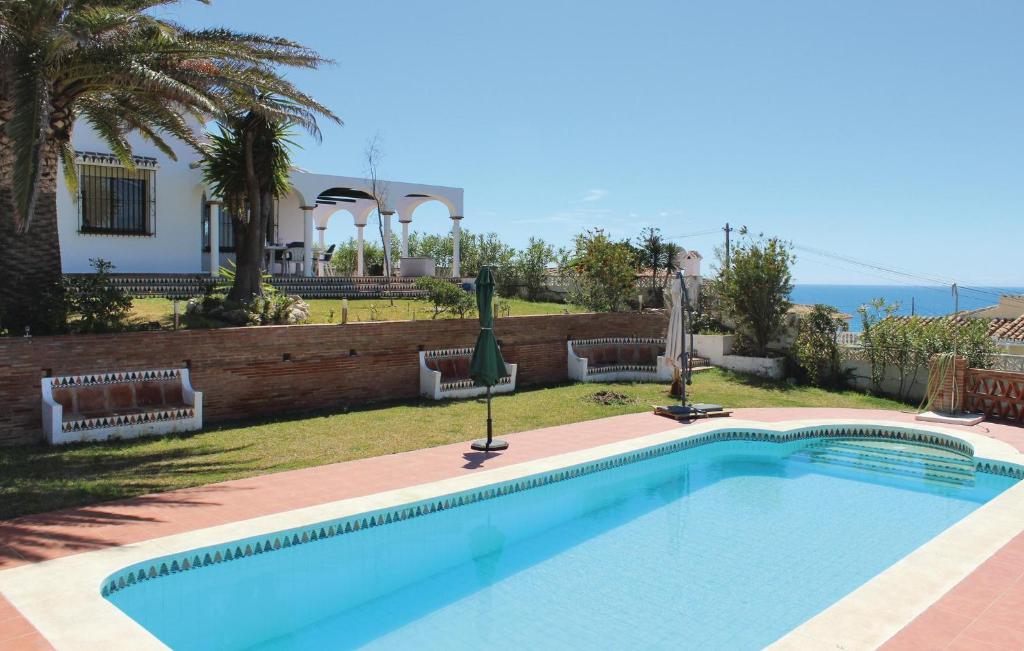 米哈斯科斯塔Nice Home In Las Farolas With Kitchen的房屋前的游泳池
