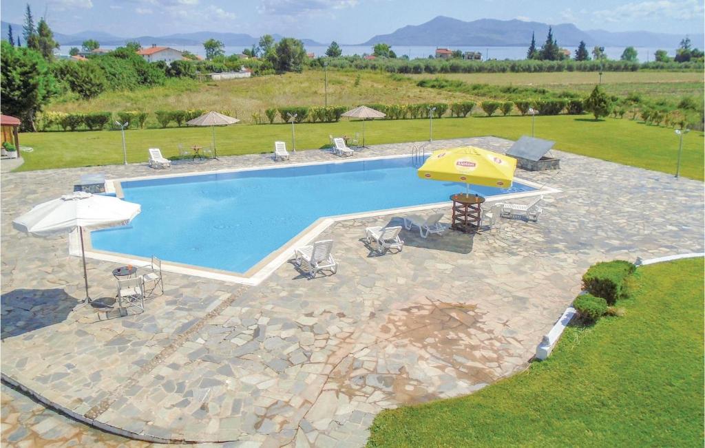 卡梅纳维洛拉Gorgeous Home In Kamena Vourla With Outdoor Swimming Pool的游泳池配有黄色遮阳伞和椅子