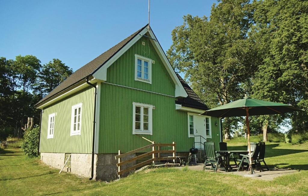 MöljerydAmazing Home In Kallinge With Kitchen的一个带桌子和雨伞的绿色房子
