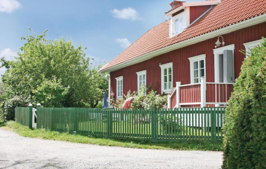 松德比Awesome Home In Eskilstuna With 2 Bedrooms And Wifi的一座带绿色围栏的红色房子