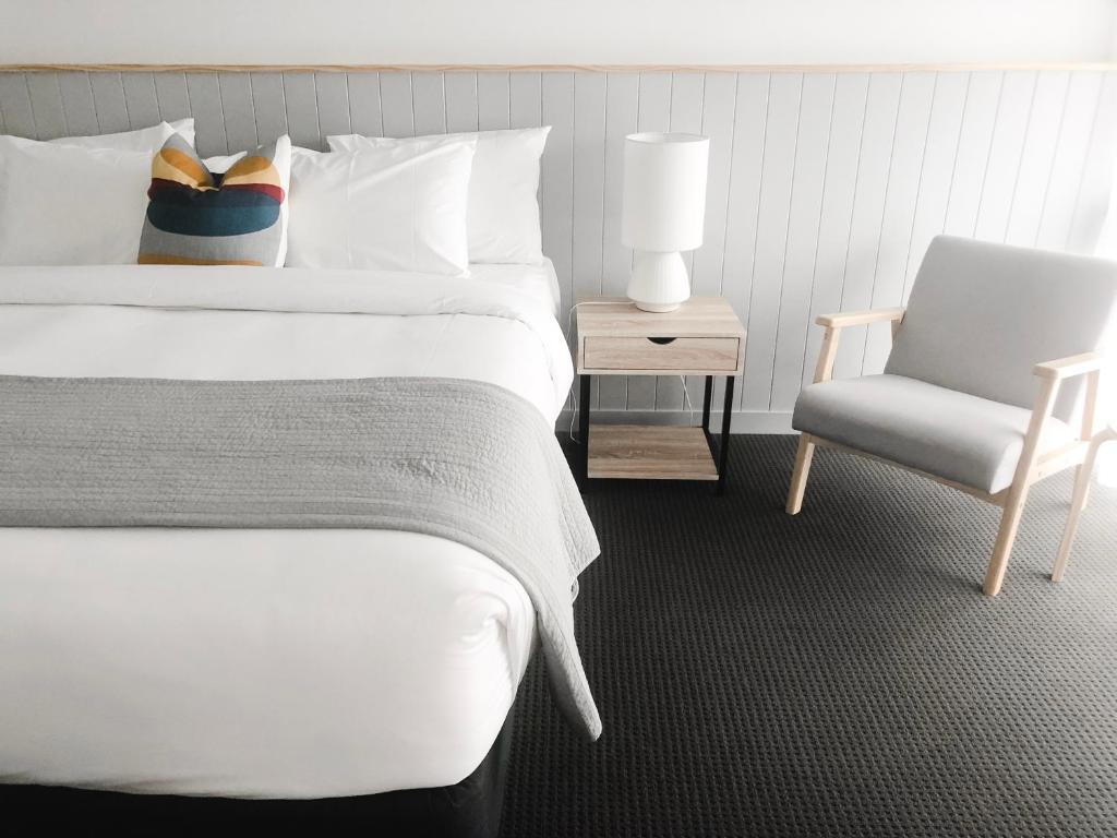 沃纳姆堡八斯班斯酒店的卧室配有白色的床和椅子