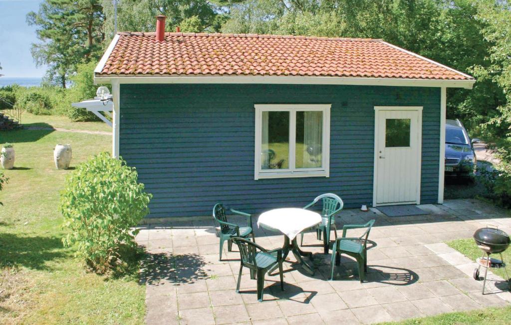费尔耶斯塔登Gorgeous Home In Frjestaden With Wifi的蓝色的小房子,配有桌子和椅子