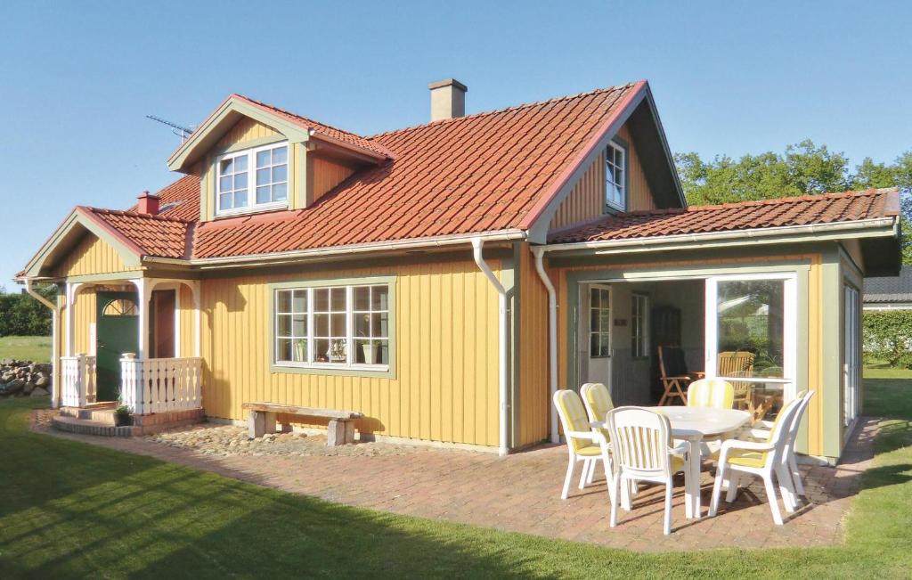 FalkvikAwesome Home In Slvesborg With Kitchen的黄色的房子,配有桌子和椅子