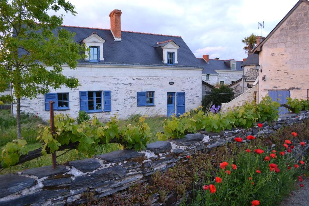 La Daguenière德格鲁瓦度假屋的一座带红色鲜花的花园的房子