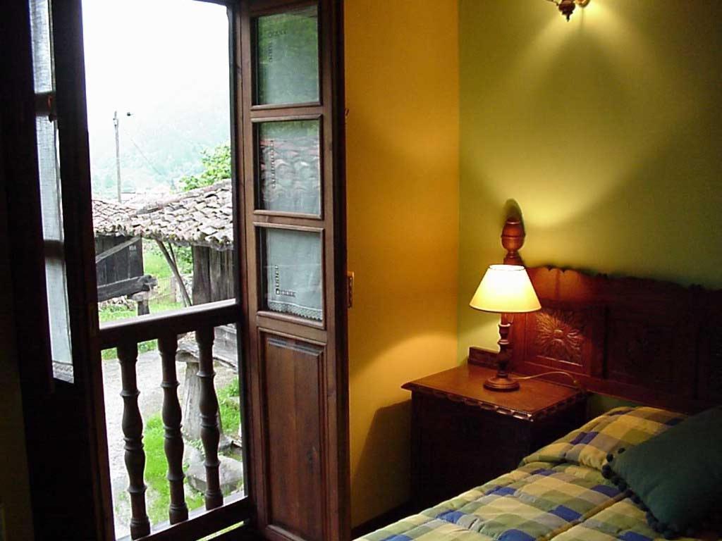 EspinaredoCasa rural Espinareu的一间卧室设有窗户、一张床和一盏灯。