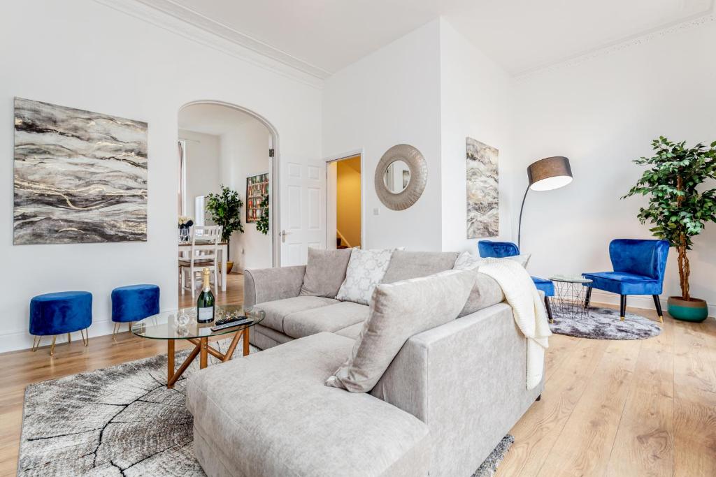 伦敦Bright & Spacious 4beds home - Kensington High Street-Olympia的客厅配有沙发和蓝色椅子