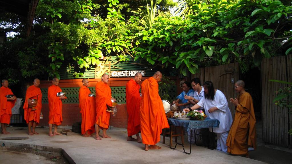 北碧PY旅馆的一群身着橙色长袍的僧侣站在桌子旁