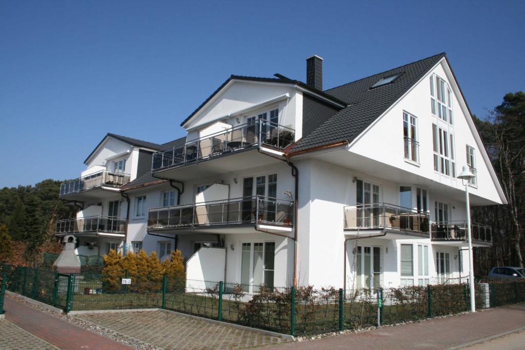 蒂索Ferienwohnung Sonnenstrand Whg 12的带阳台和围栏的白色建筑