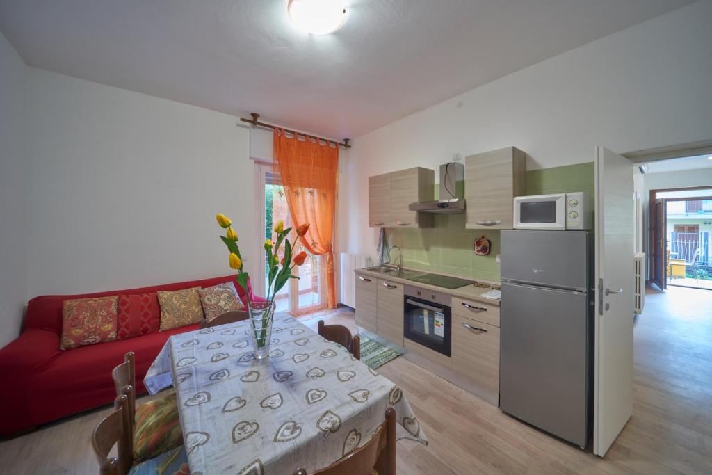 阿巴迪亚拉里亚纳Casa della nonna的厨房以及带桌子和红色沙发的客厅。