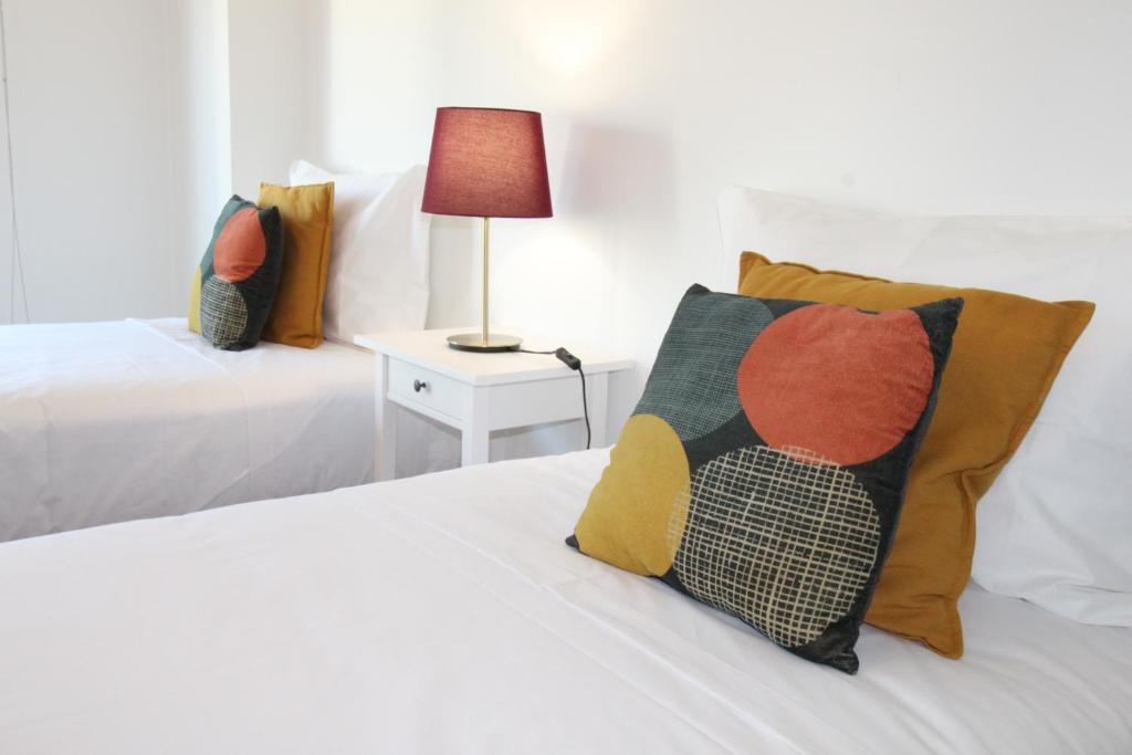 里斯本Parque das Nacoes River view ,free wifi的一间卧室配有两张床和一张带台灯的桌子