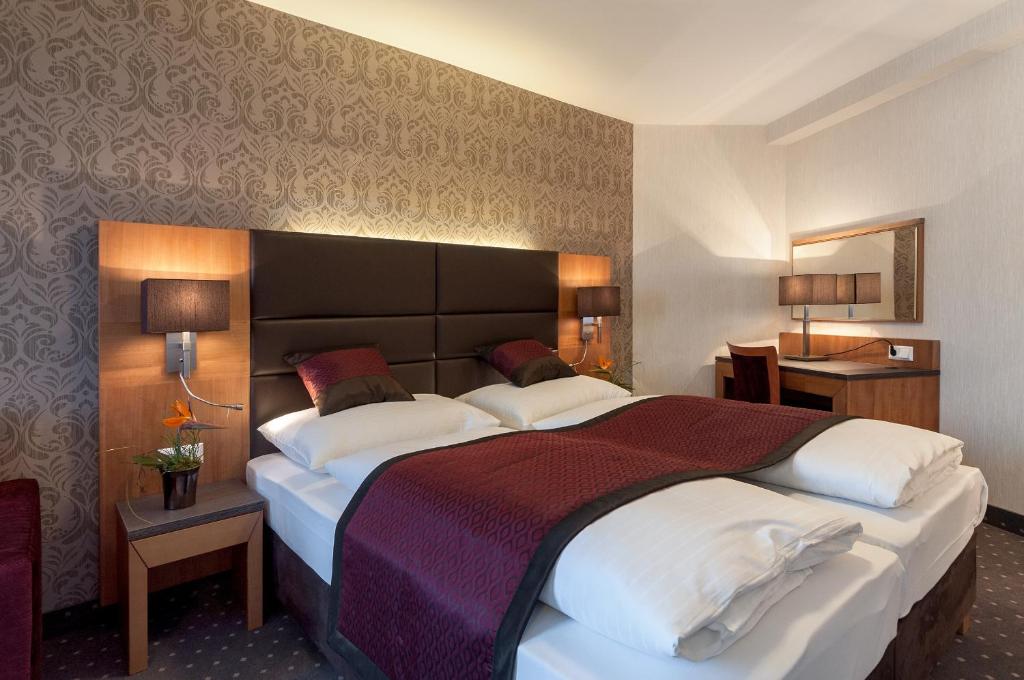 维也纳科尔蒂纳丹俱乐部酒店的酒店客房配有一张带白色枕头的大床