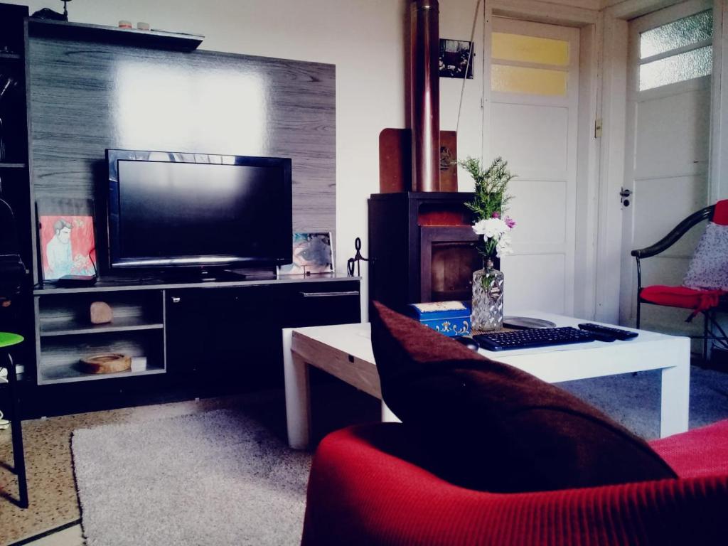 蒙得维的亚Casa del Mar的一间带电视和红色椅子的客厅