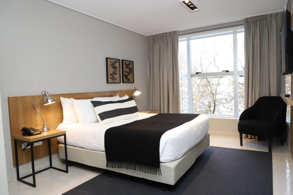门多萨Agua del Corral Hotel & Spa的卧室配有床、椅子和窗户。