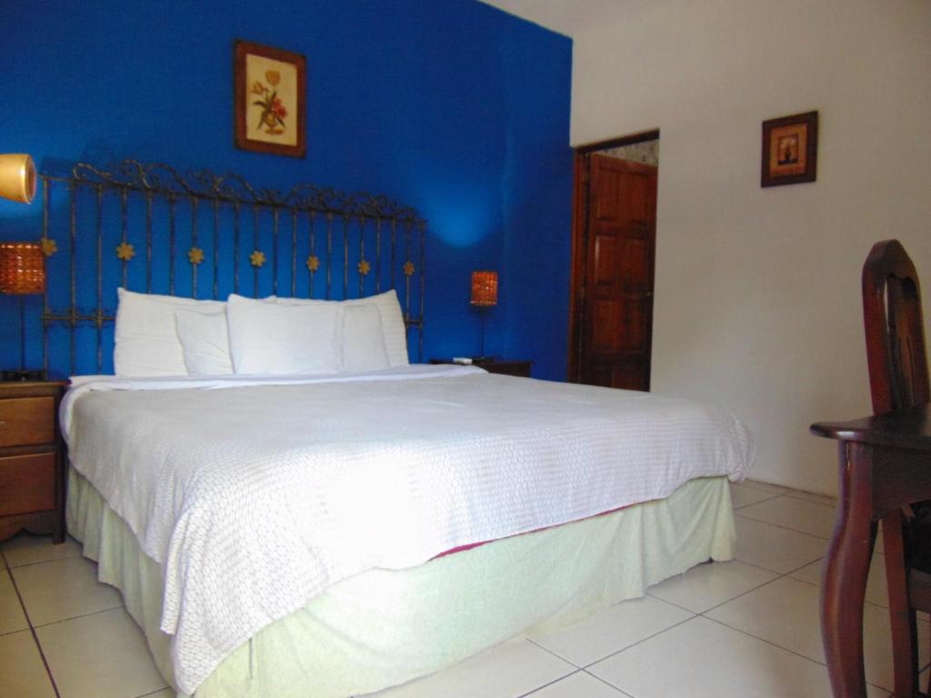 马那瓜Managua Hills的一间卧室设有一张蓝色墙壁的大床