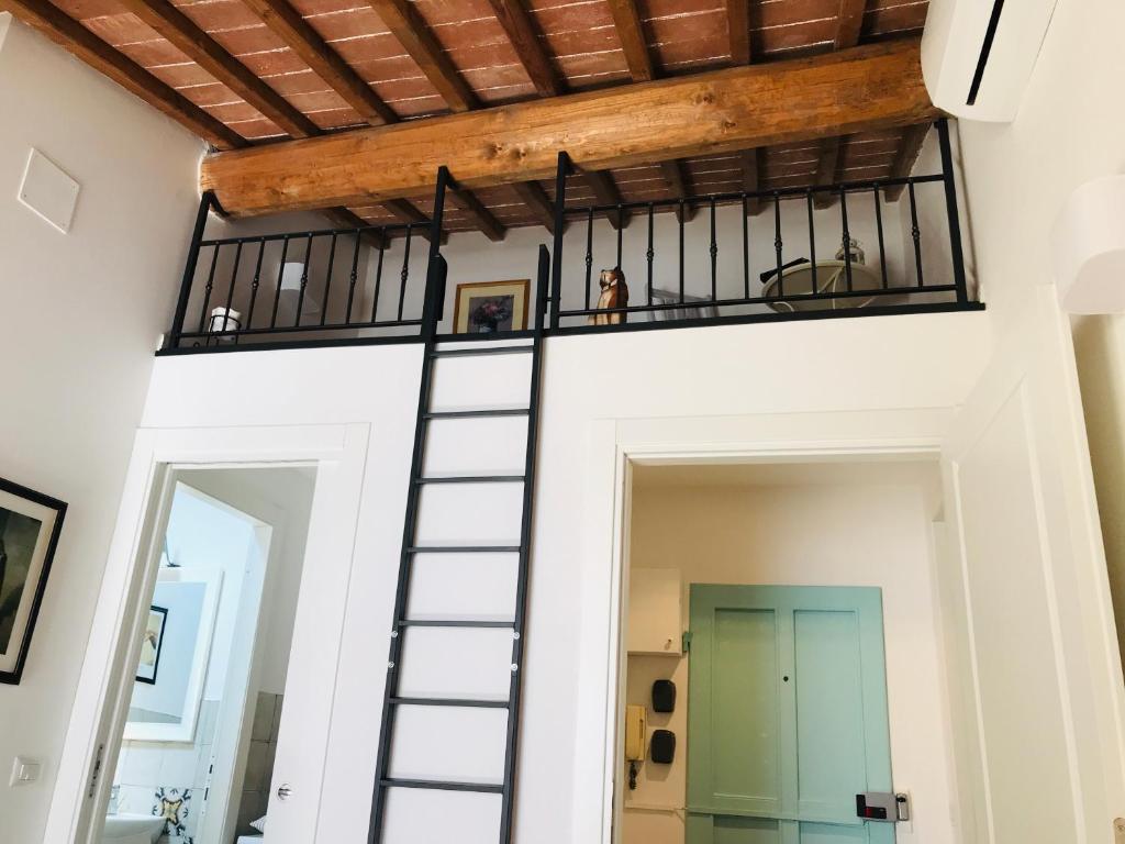 普拉托CALIMARA18 25" from Florence AC SmartTV的房屋内的一个房间,设有螺旋楼梯