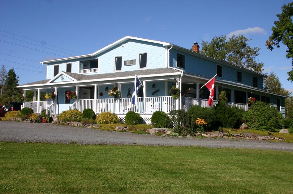 巴德克奥尔德农场住宿加早餐酒店的白色的房子,有白色的栅栏和旗帜