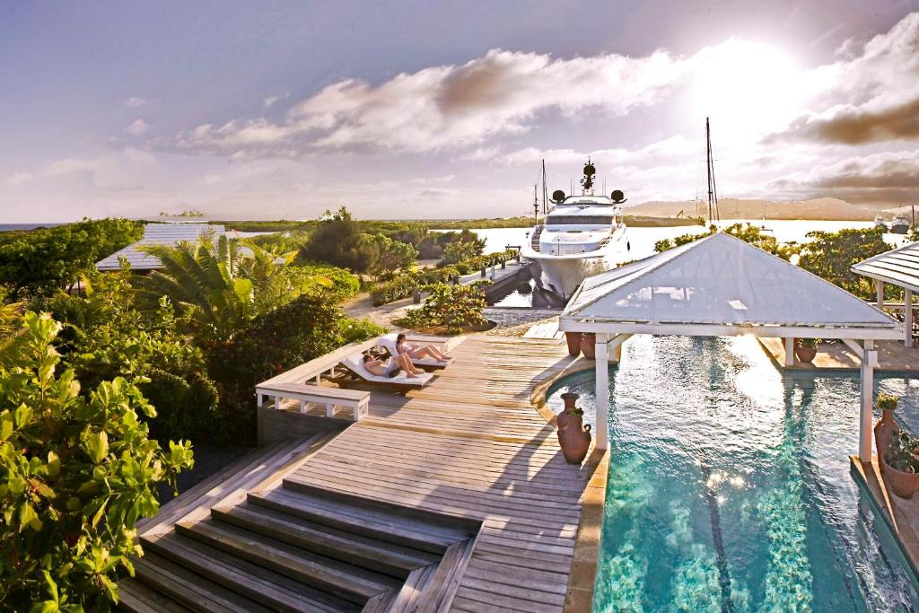 罗阿坦Barefoot Cay Resort的停泊在游泳池旁的码头上的船只