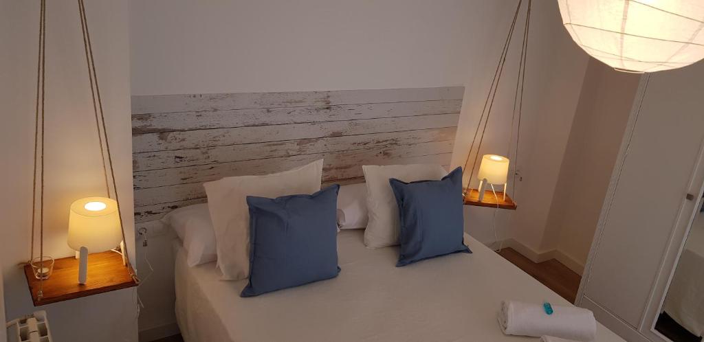 塞戈尔韦Alojamientos Segóbriga Rural (Tahona)的一间卧室配有一张带蓝色枕头的床和两盏灯