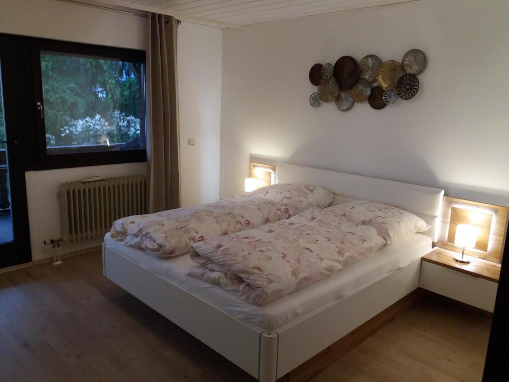巴特迪克海姆Ferienwohnung Lingenfelder的一张位于带两盏灯和一扇窗户的房间的床铺