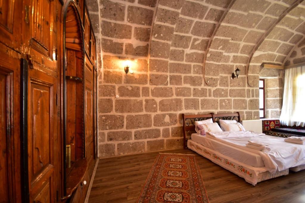 GuzelyurtKapadokya Ihlara Günalp Konağı的一间卧室设有一张床和石墙