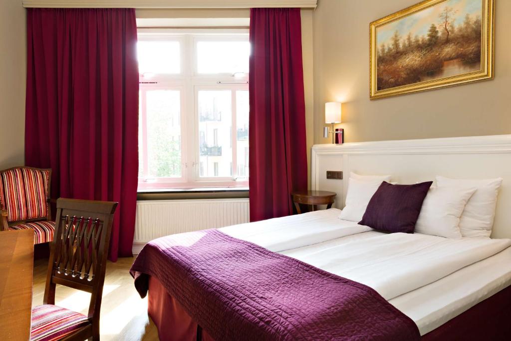 哥德堡Hotel Vasa, Sure Hotel Collection by Best Western的一间卧室配有一张带红色窗帘的大床