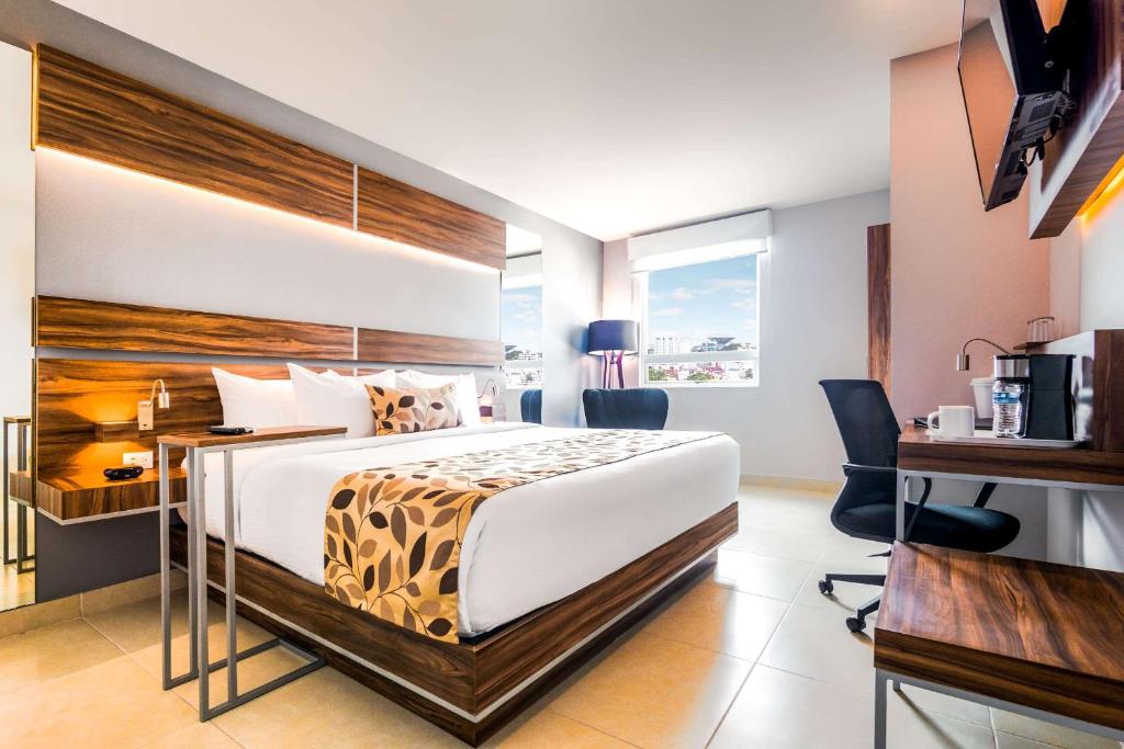 比亚埃尔莫萨Sleep Inn Villahermosa的配有一张床和一张书桌的酒店客房