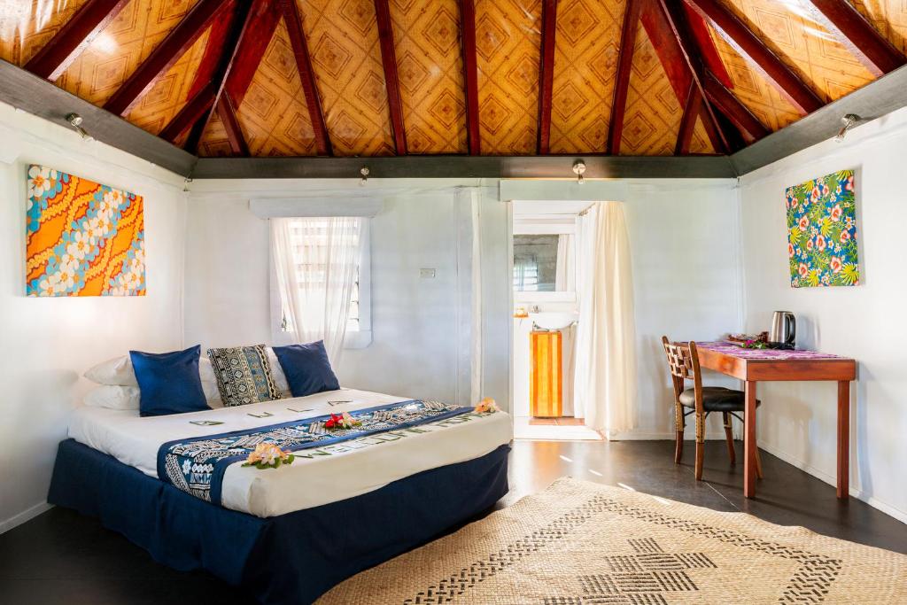 劳托卡Belo Vula Island Resort Limited的一间卧室配有一张床、一张桌子和一张书桌