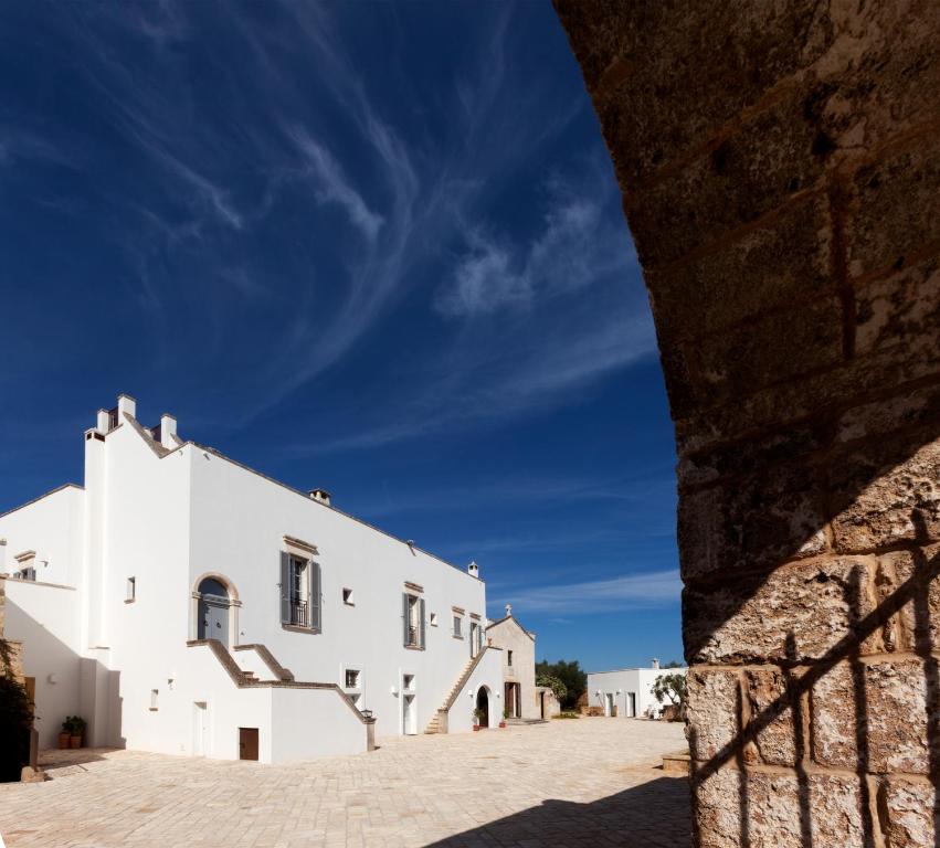 莱切Masseria Borgo Mortella的白色的建筑,一侧设有楼梯