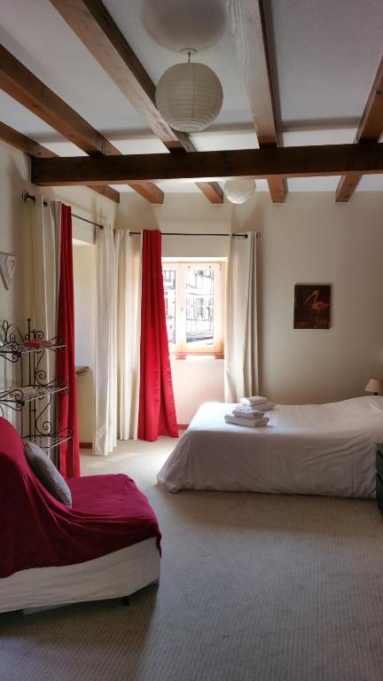 奥贝奈Chambres touristiques La Cour Des Hôtes的一间卧室设有两张床和红色窗帘