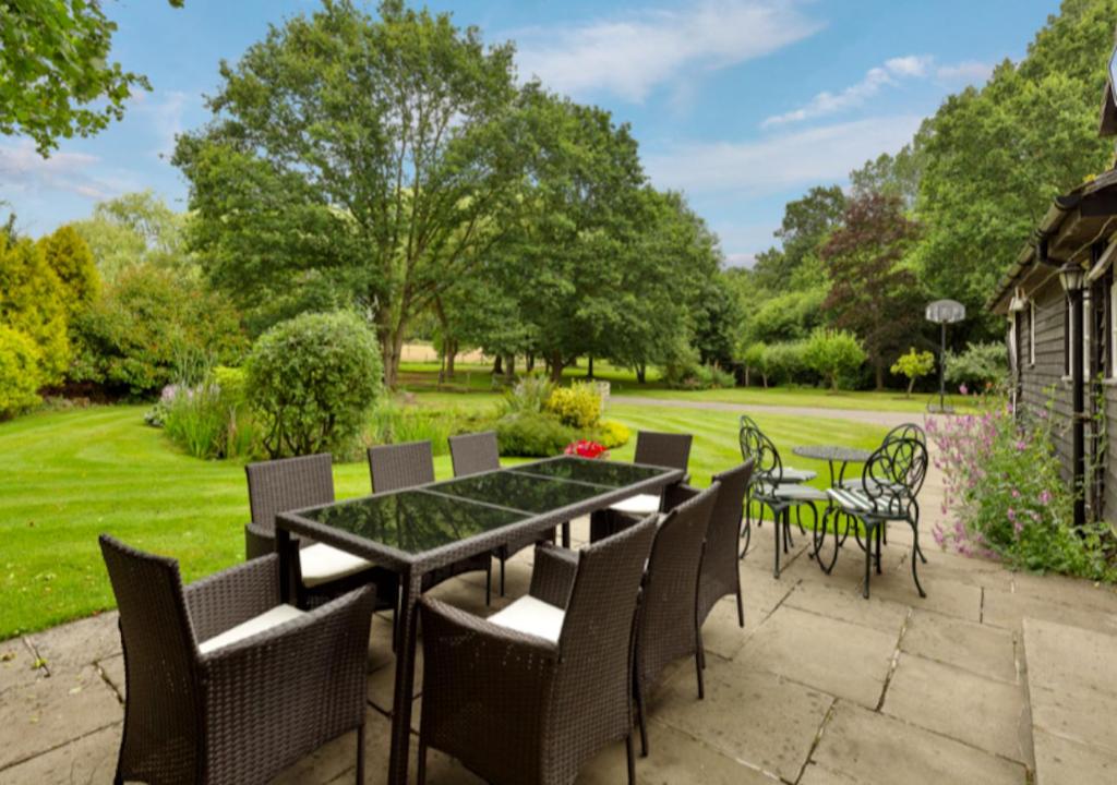 吉尔福德White Lodge House的一个带桌椅的庭院和一个草坪