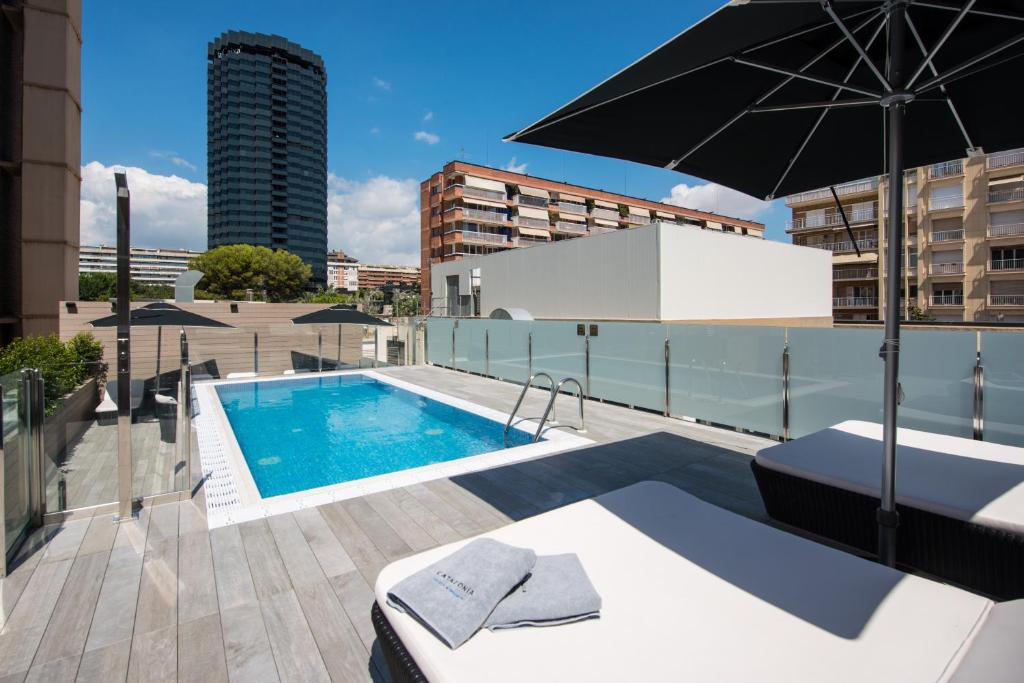 巴塞罗那里戈雷托加泰罗尼亚酒店的一座带遮阳伞的大楼的顶部游泳池