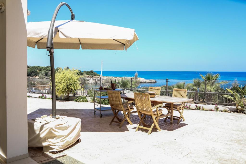 帕拉利米尼Phaedrus Living: Seaside Luxury Villa Anafi的庭院配有桌椅和遮阳伞。