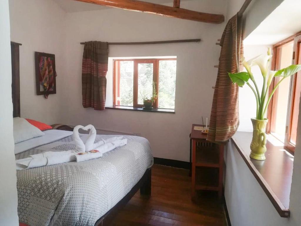 奥兰太坦波Casa Patacalle的一间卧室配有两张床,床上有天鹅