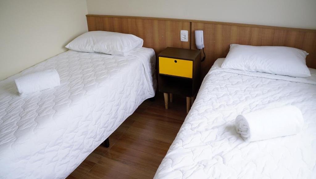 圣保罗Hotel Casa Ocarina的带床头柜的客房内的两张单人床