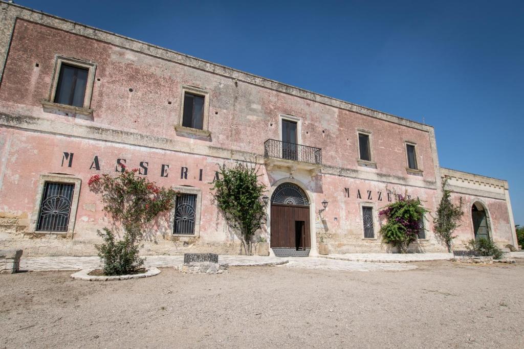 圣潘克拉齐奥萨伦蒂诺Masseria Mazzetta Salento Corte del Falconiere B&B的一座古老的砖砌建筑,名字叫修道院