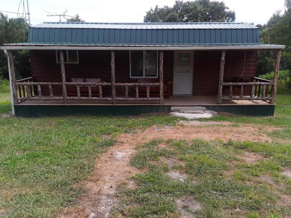 MarshallAmish made cedar cabin with a loft on a buffalo farm close to the Buffalo River的一座小木房子,在田野上设有门廊