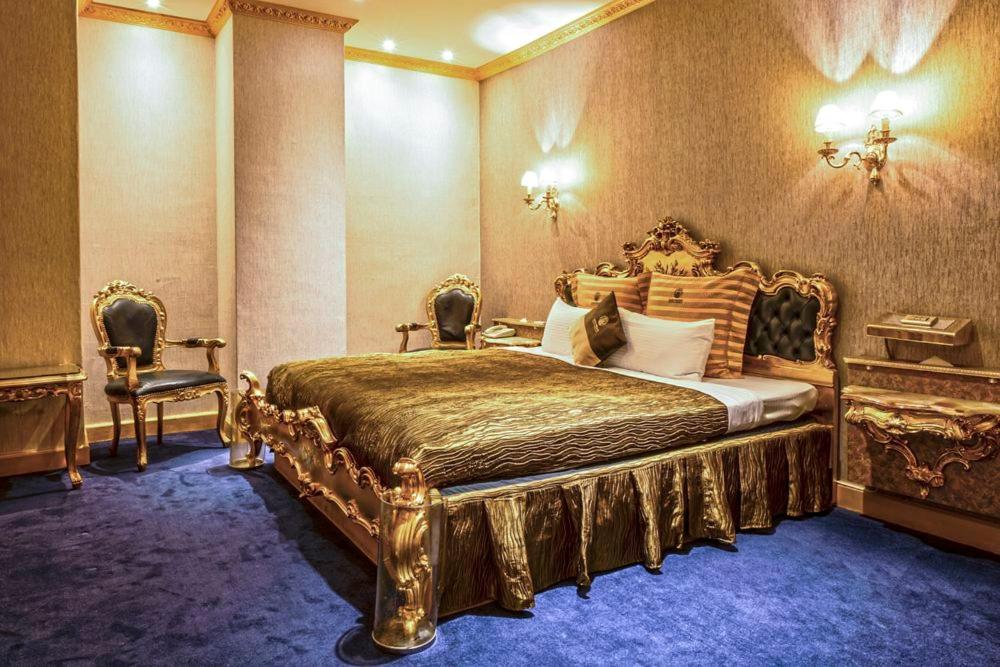 台北和怡商旅 (原法皇)的一间卧室配有金色床和两把椅子