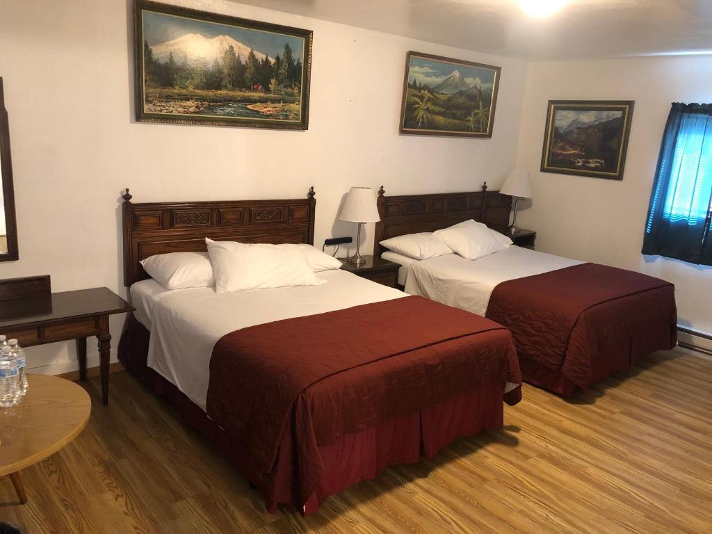 安吉利斯港安吉利斯汽车旅馆的酒店客房设有两张床和一张桌子。