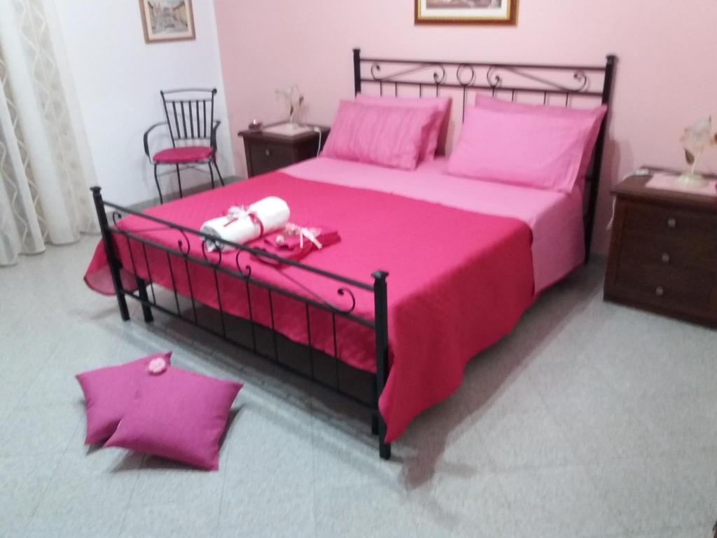 加利亚诺德尔卡波Casa Vacanze " IL PONTE "的一间卧室配有粉红色的床、粉红色的床单和粉红色的枕头
