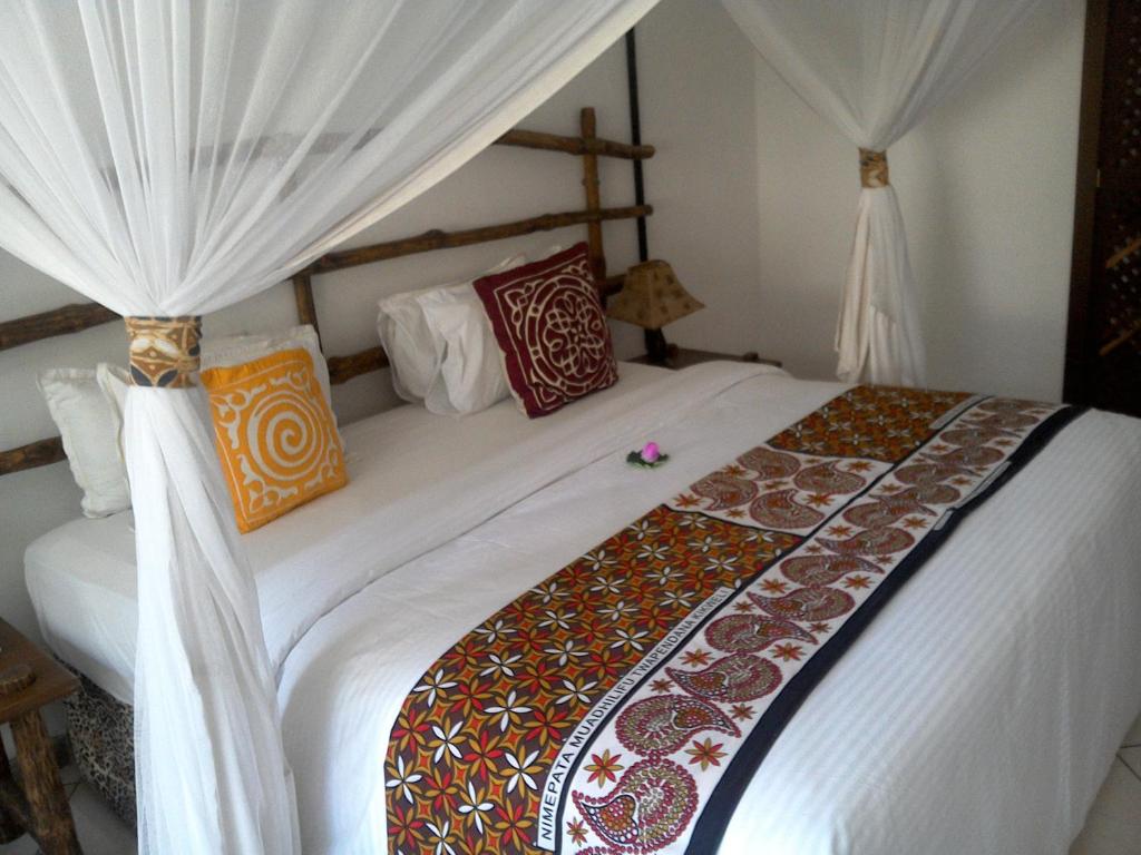 班布里蒙巴萨卡哈马酒店的卧室配有一张带白色窗帘的大床