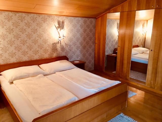茵特斯托德艾林格豪斯公寓酒店 的一间卧室配有一张大床和镜子