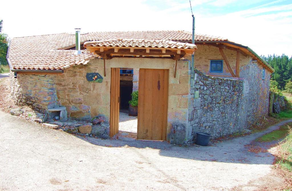 索尔波Casa do Polo A Vilerma Ribeira Sacra的路边有门的小石屋
