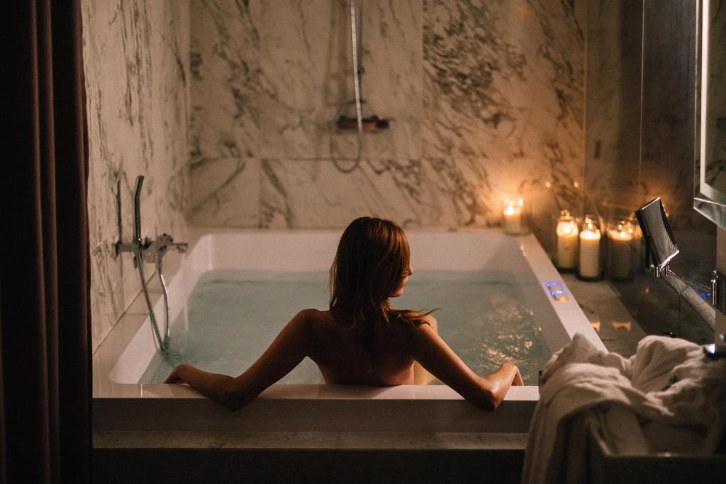 罗马罗马哈尔定制套房酒店的坐在浴室浴缸里的女人