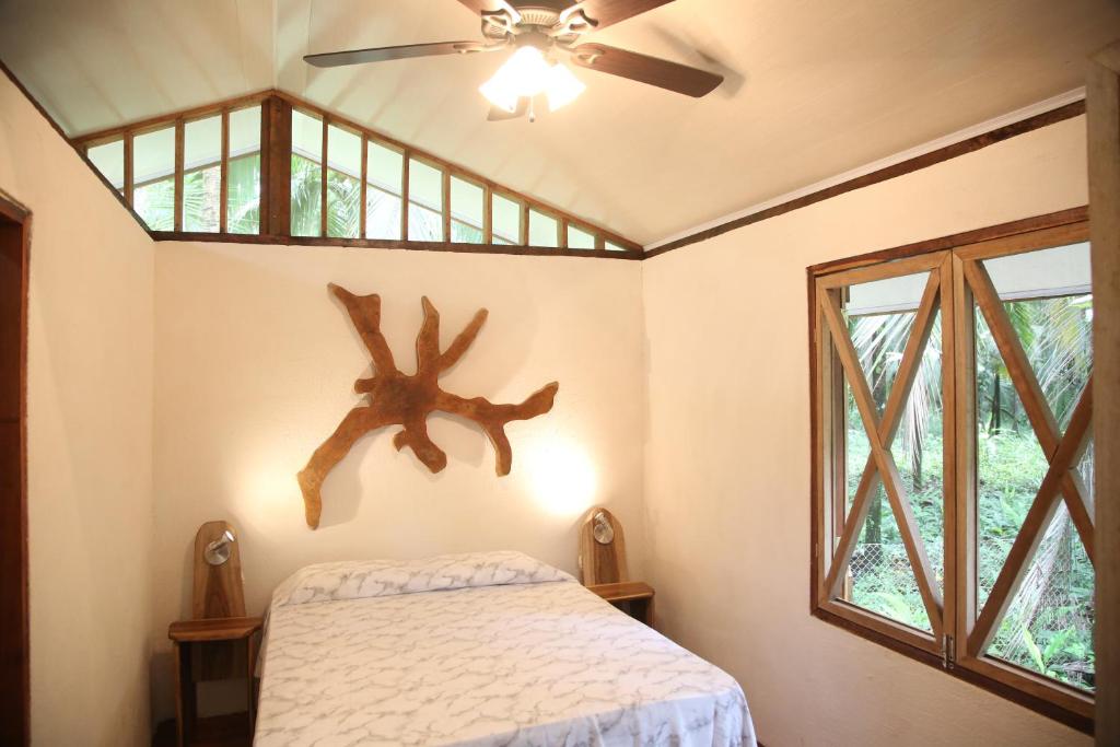 卡维塔加勒比海秘密度假屋的一间卧室配有一张床和吊扇