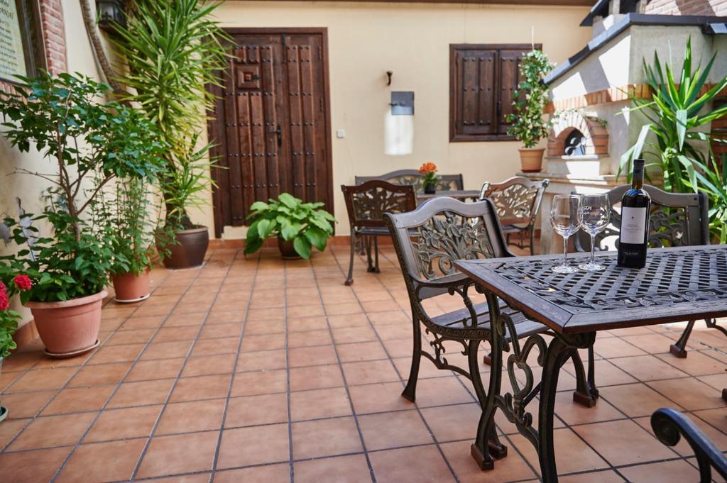 帕斯特拉纳Hostal Rural Los Telares的庭院配有桌椅和植物