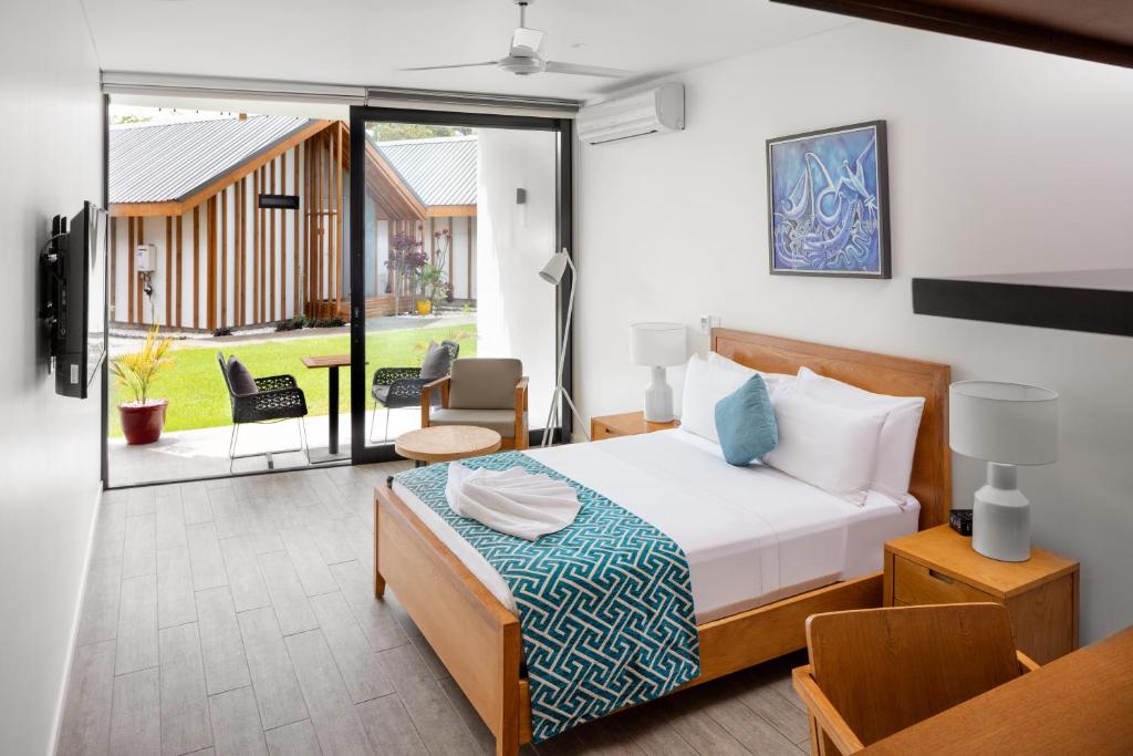 霍尼亚拉珊瑚海度假村的一间卧室设有一张床和一个阳台