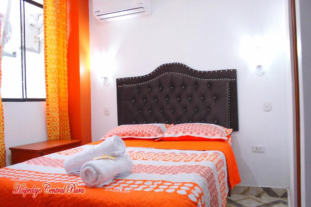 皮乌拉Hospedaje Central Piura的一间卧室配有橙色和白色床单。